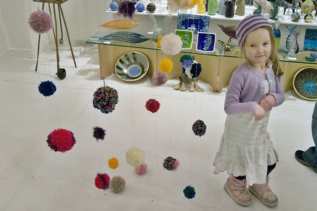 Lola and the pom-poms, "Yule Yarn" by Pat Infanti which inspired Becki to start making pom-poms last time we came here